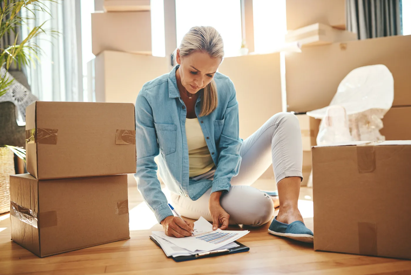 Moving paperwork and packed boxes on an apartment floor