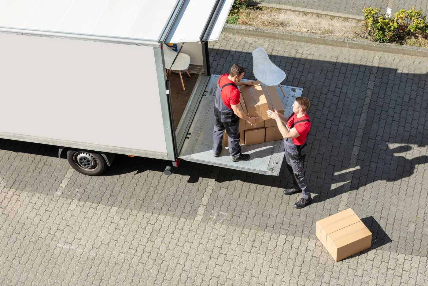 Moving crew unloading boxes from the back of a truck